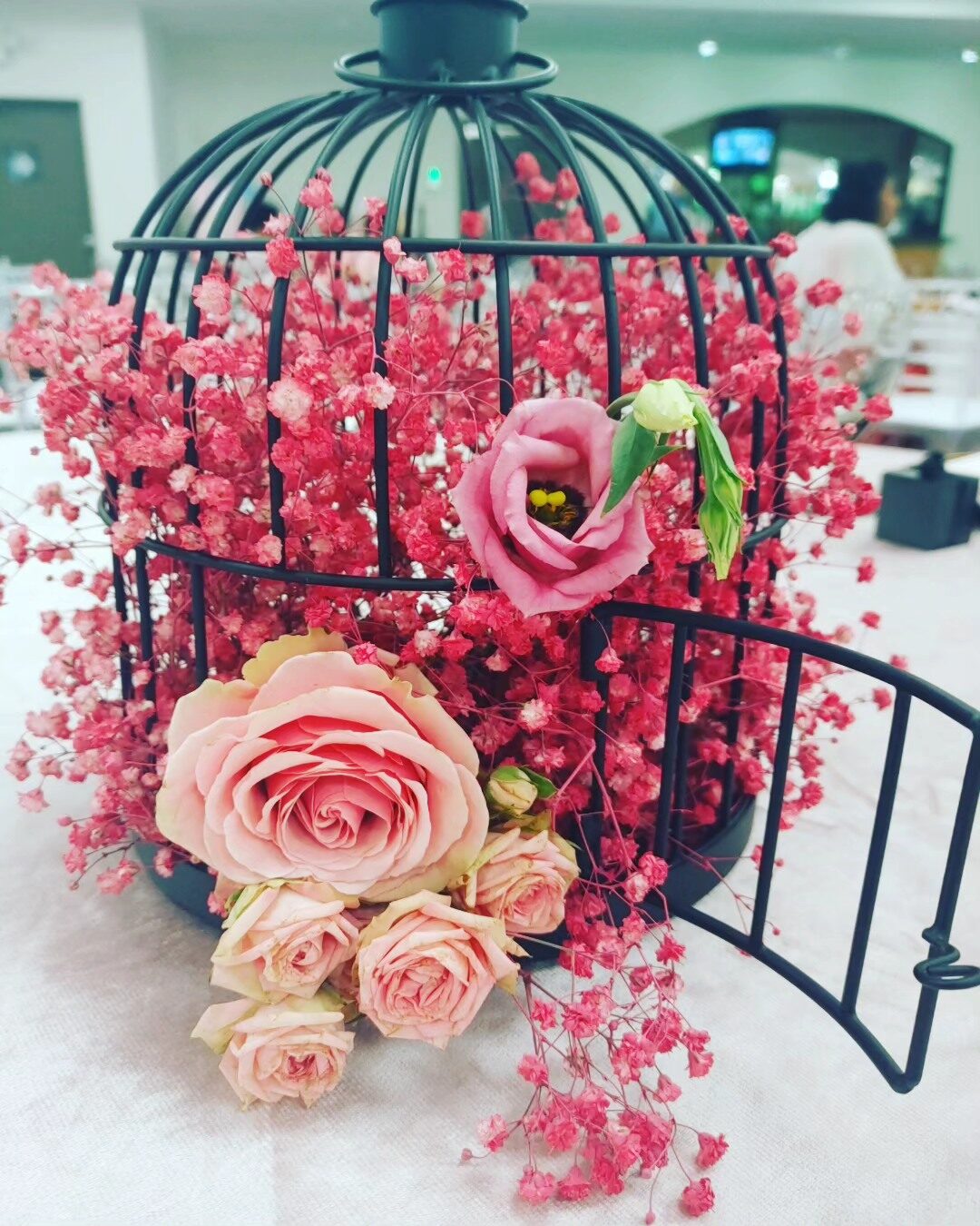 Birdcage centerpiece with pink roses and baby's breath