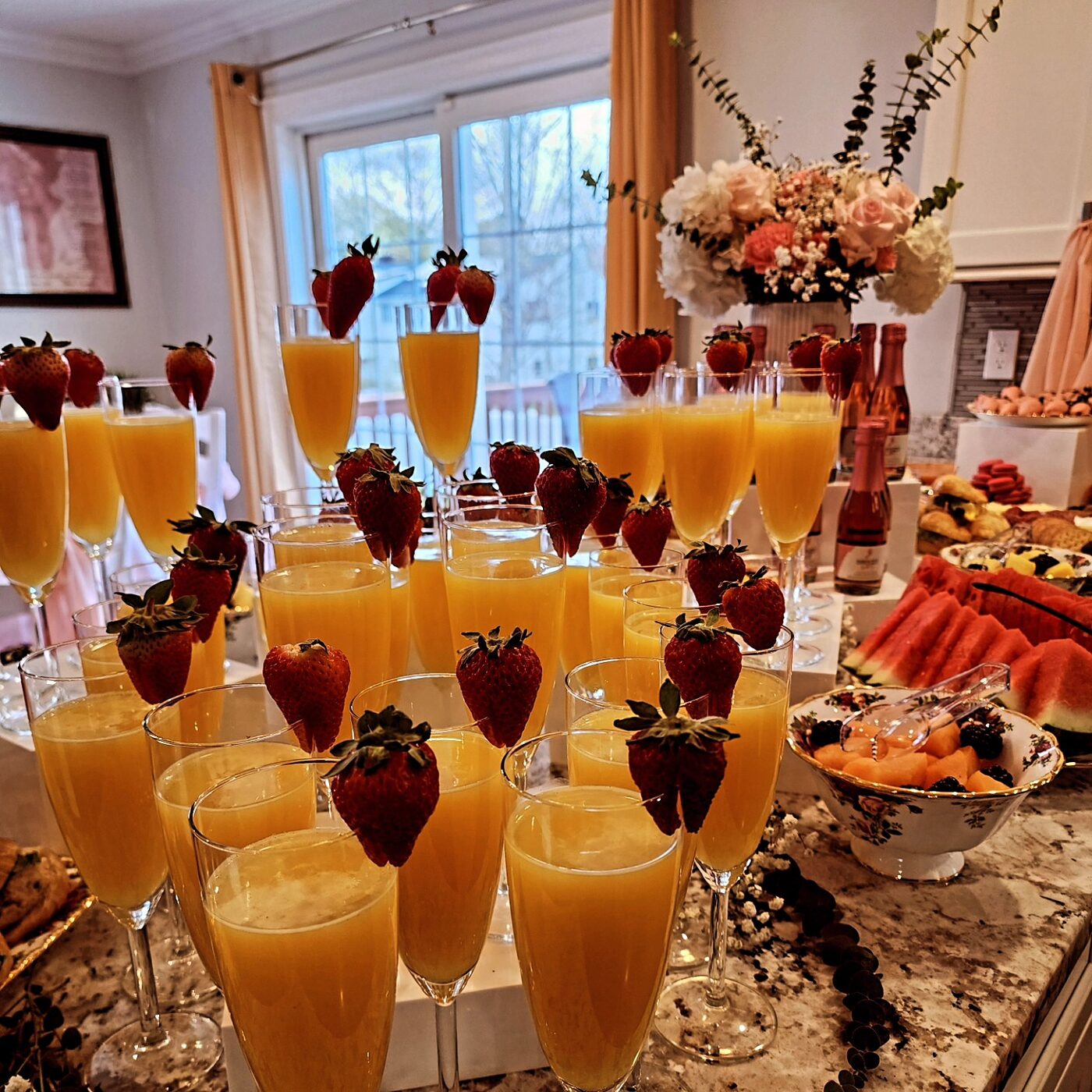 Mimosa bar with orange juice and strawberries, brunch spread